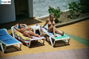 Girls sunbathe topless near the pool. Thumbnail 39
