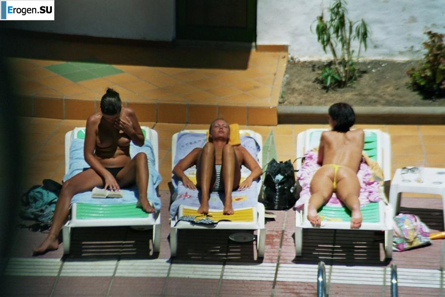 Girls sunbathe topless near the pool. Part 3. Slide 14