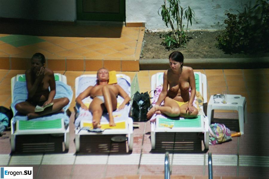 Girls sunbathe topless near the pool. Part 3. Slide 18