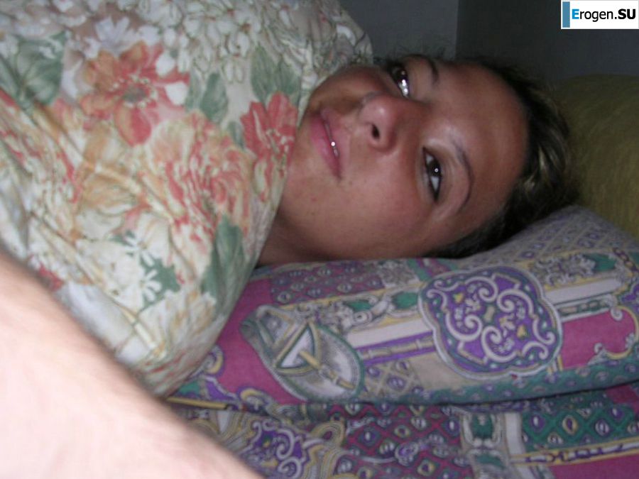 A tanned brunette shines her tits in the morning in bed. Slide 12