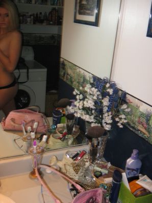 Chic blonde poses without a bra in the bathroom in front of the mirror. Thumbnail 11