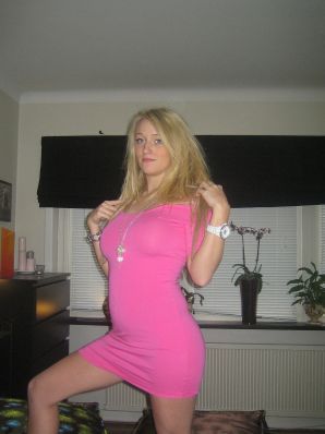 A blonde with silicone breast poses in a short skirt. Thumbnail 14