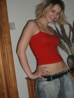 A blonde with a thin waist poses in glasses and red panties. Part 2. Thumbnail 1